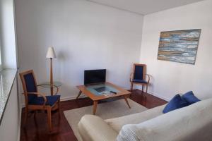 a living room with a couch and a table and chairs at Casa da Praça 2 in São João da Madeira