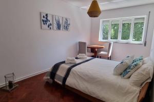 a bedroom with a bed and a table and a window at Casa da Praça 2 in São João da Madeira