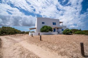 uma casa branca no meio de uma estrada de terra em Cas Saliners - Parc Natural em La Savina