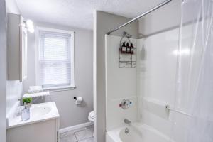 uma casa de banho branca com um chuveiro e um lavatório. em 3BR Home with In-Unit Laundry, Parking, Sound Bar em Rochester