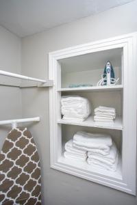 um armário com toalhas brancas numa prateleira em 3BR Home with In-Unit Laundry, Parking, Sound Bar em Rochester