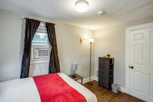 een slaapkamer met een bed met een rode deken en een raam bij 3BR Home with In-Unit Laundry, Parking, Sound Bar in Rochester