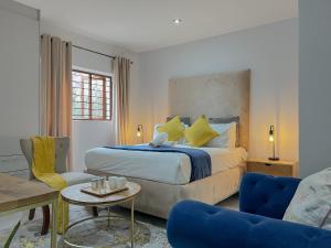 约翰内斯堡Amoris Guesthouse - In Randburg的一间卧室，配有一张床、一张桌子和几把椅子