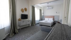 a hotel room with a bed and a television at Büyükada Ece Suit in Adalar