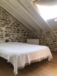 a bed in a room with a stone wall at Dreamy Cottage in Ayiá