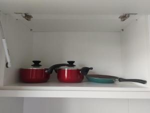 dos ollas y sartenes en un estante de una cocina en Apartamento luxo no centro en Ubá