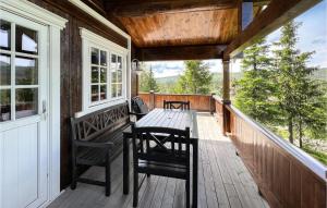 une terrasse couverte en bois avec une table et des chaises. dans l'établissement Amazing Home In Nord-torpa With Kitchen, à Nord Torpa
