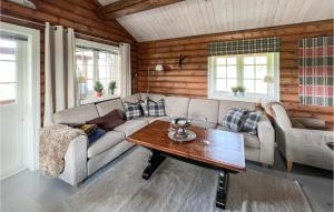 a living room with a couch and a table at Amazing Home In Nord-torpa With Kitchen in Nord Torpa