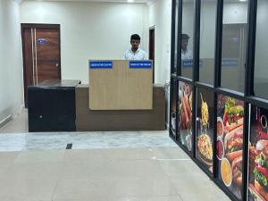 a man is standing behind a counter in a building at Hotel Skymoon Luxury Rooms in Hyderabad
