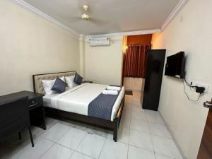 a bedroom with a bed and a desk and a television at Hotel Skymoon Luxury Rooms in Hyderabad