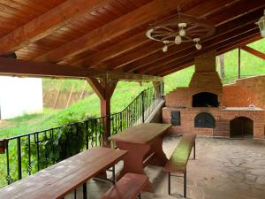 a patio with a picnic table and a brick fireplace at Casa Larisa in Vişeu de Sus