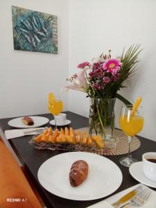 un tavolo con piatti di cibo e un vaso di fiori di Apartmani Glavinić a Čibača