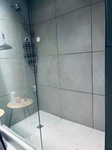 y baño con ducha y puerta de cristal. en ModernLuxe Apartment, en Windhoek