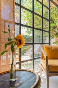 a vase with a yellow flower on a table in front of a window at The Pearl - Marbella in Marbella