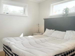 ein großes weißes Bett in einem Schlafzimmer mit Fenster in der Unterkunft Holiday home BORGHOLM XVII in Borgholm
