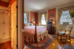 een slaapkamer met rode muren en een bed en een stoel bij Francis Malbone House in Newport