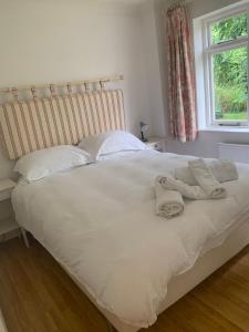 a white bed with a towel on top of it at The Cottage Hankerton Priory in Hankerton