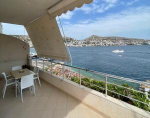 a balcony with a table and chairs and a view of the water at Port Side Sarande in Sarandë