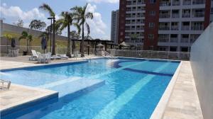 a large blue swimming pool in a building at Apartamento completo in Manaus