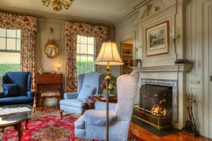 a living room with two chairs and a fireplace at Francis Malbone House in Newport