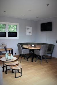 een woonkamer met een tafel en stoelen en een televisie bij Ferienhaus Aurora, Sauna, Seeblick, angeln in Twist