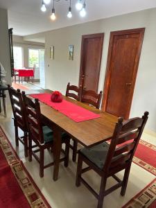 a dining room table with chairs and a red napkin on it at Pensiune Daniela in Corbeni +25 photos