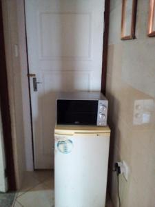 a microwave sitting on top of a refrigerator at Stonebass Lodge in Newlands