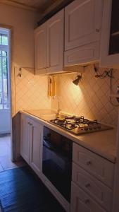 een keuken met witte kasten en een fornuis met oven bij La Casa di Cesi in San Gemini