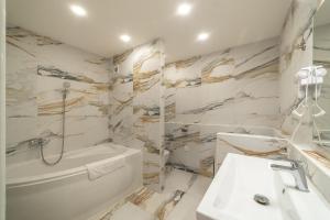 a white bathroom with a tub sink and a toilet at AR Rezidencia Fibichova in Košice +21 photos