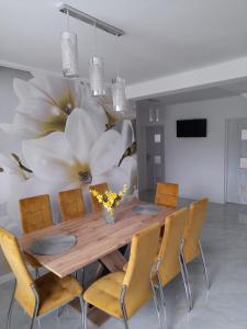 a dining room with a table and chairs and a large flower mural at Apartmany Dianka in Veľký Slavkov