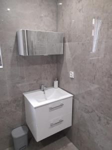a bathroom with a white sink and a mirror at Apartmany Dianka in Veľký Slavkov