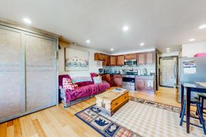uma sala de estar com um sofá roxo e uma cozinha em Charming Pad em Granby