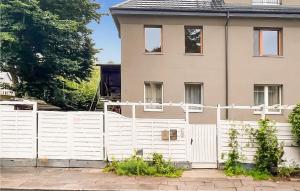 a white fence in front of a house at Beautiful Home In Swinoujscie With Kitchen in Świnoujście