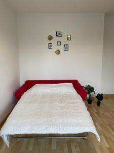 a white bed in a room with a red headboard at Maison Triplex à deux pas du centre ville in Saint-Dizier