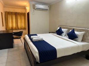 a bedroom with a large bed with blue pillows at Hotel Skymoon Luxury Rooms in Hyderabad