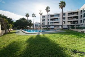 un gran edificio con piscina y palmeras en 086 Retro Mayor Holiday - Alicante Holiday, en La Mata