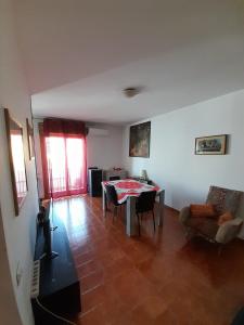 a living room with a table and chairs at Central Apartment Torino N.22 in Olbia