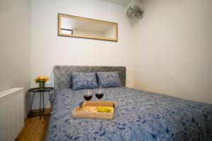 a bed with a tray with two glasses of wine at Fort63 house in Kaunas