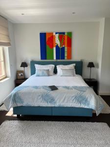 Schlafzimmer mit einem Bett mit blauem Kopfteil in der Unterkunft Domaine de La Noiseraie in Rhisnes