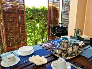 a table with a blue table cloth and pots and pans at KASPOZ Entire Holiday Home - Private garden & 5 mins walk to the beach in Mont Choisy +15 photos