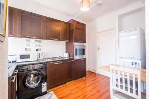 a kitchen with wooden cabinets and a dishwasher at Classic Marble Arch Apartment in London