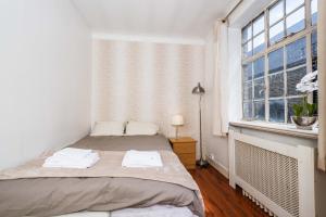 una camera bianca con un letto e una finestra di Classic Marble Arch Apartment a Londra