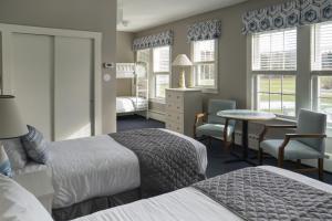 Habitación de hotel con 2 camas, mesa y sillas en Sebasco Harbor Resort, en Sebasco Estates