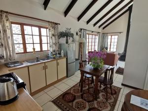 a kitchen with a table with purple flowers on it at Eagles' Rock in Underberg