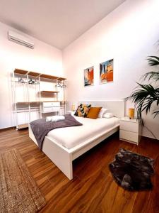 a bedroom with a large white bed and wooden floors at Jasmine L7 in Armeñime