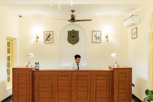 a man sitting at a reception desk in a room at HOTEL WHITE RABBIT in Pushkar