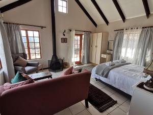 a bedroom with a king sized bed and a couch at Eagles' Rock in Underberg