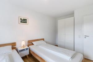 um quarto com 2 camas e um candeeiro numa mesa de cabeceira em Ferienwohnung Emma em Gutach im Breisgau