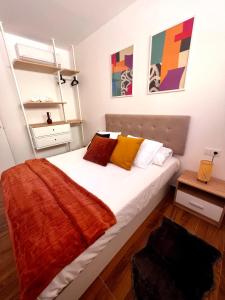 a bedroom with a large white bed with colorful pillows at Amber L5 in Armeñime