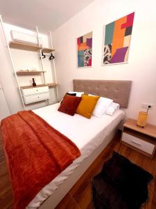 a bedroom with a large white bed with colorful pillows at Amber L5 in Armeñime +5 photos